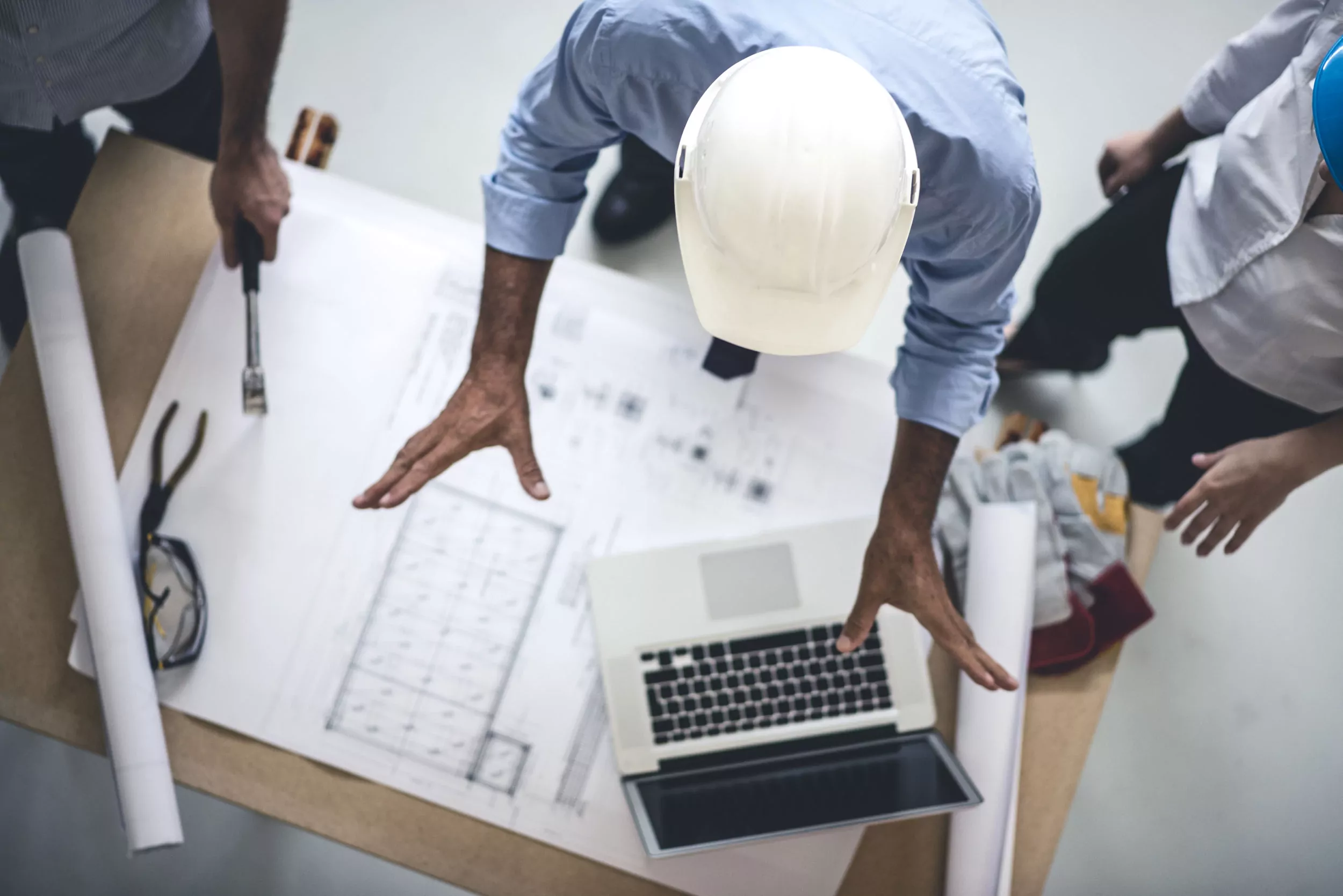 people discussing blue print contruction plan on table