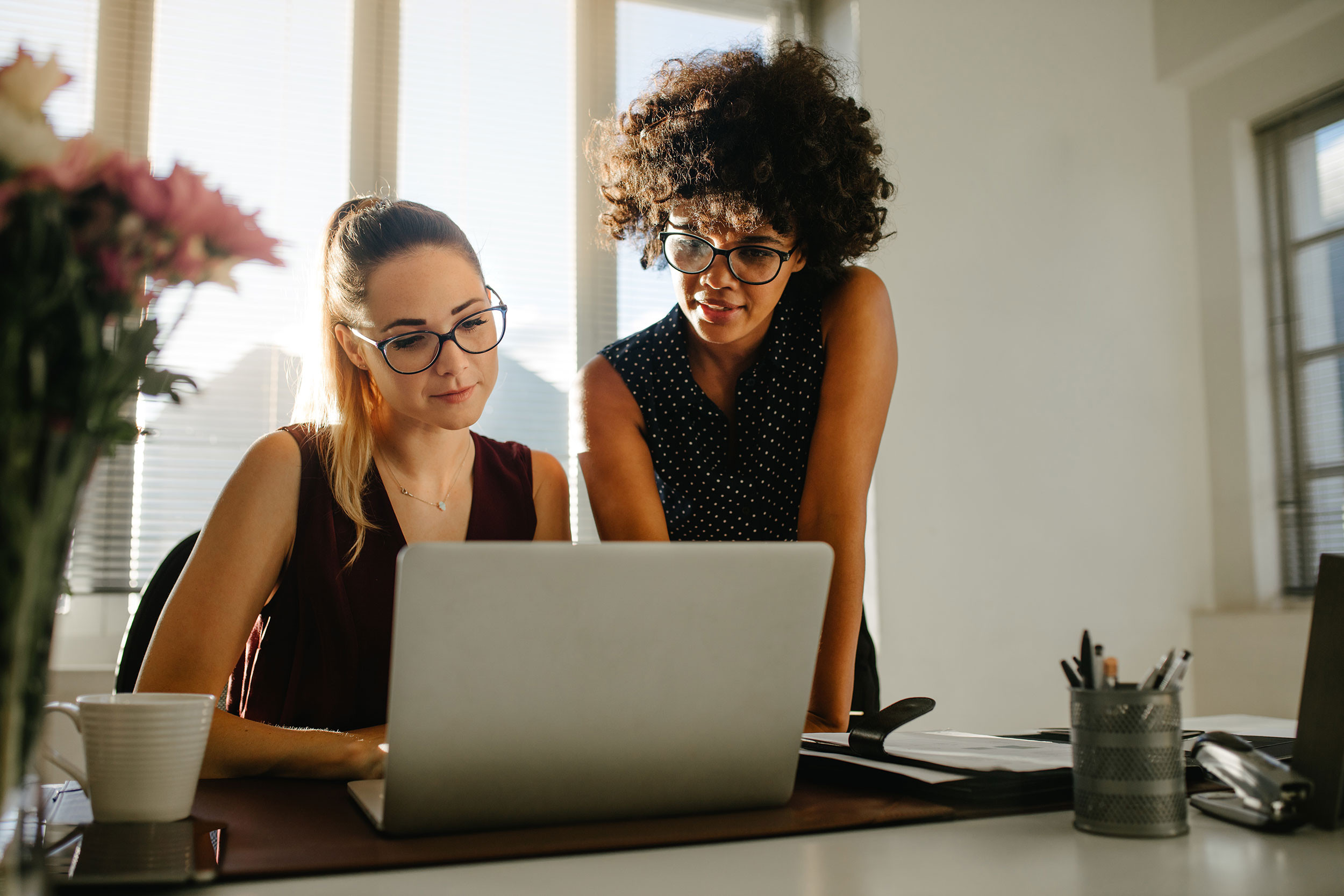 two business persons looking at laptop