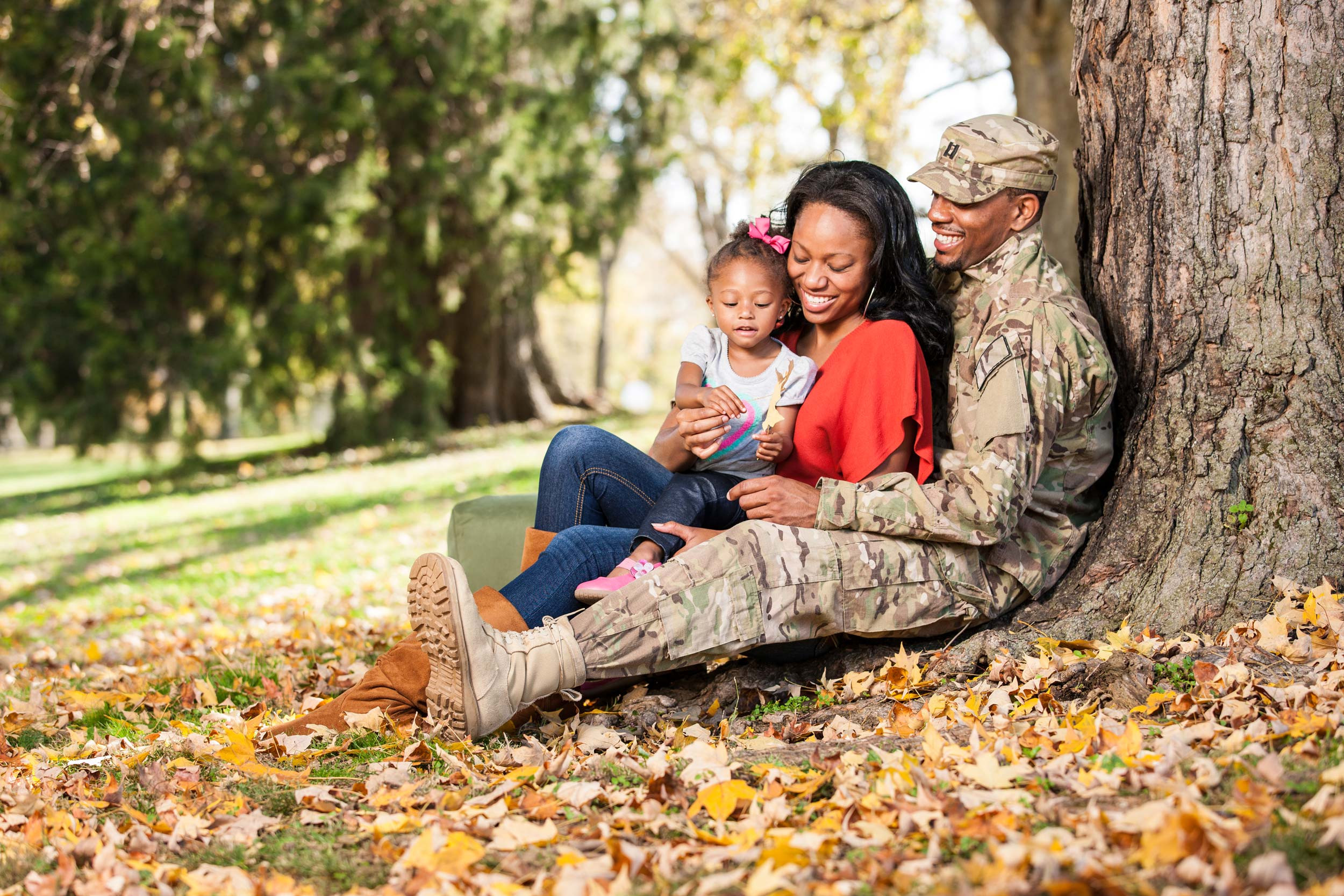 happy military family sitting in a park