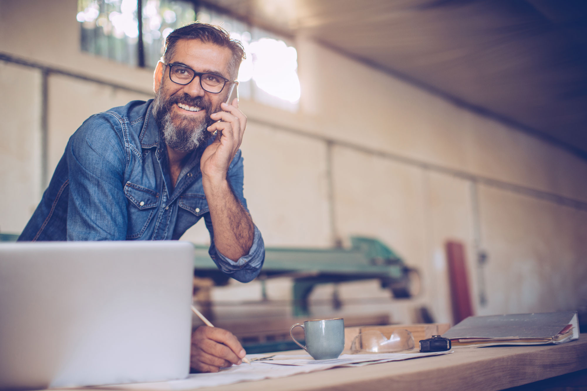 small business person talking on mobile phone with document and computer