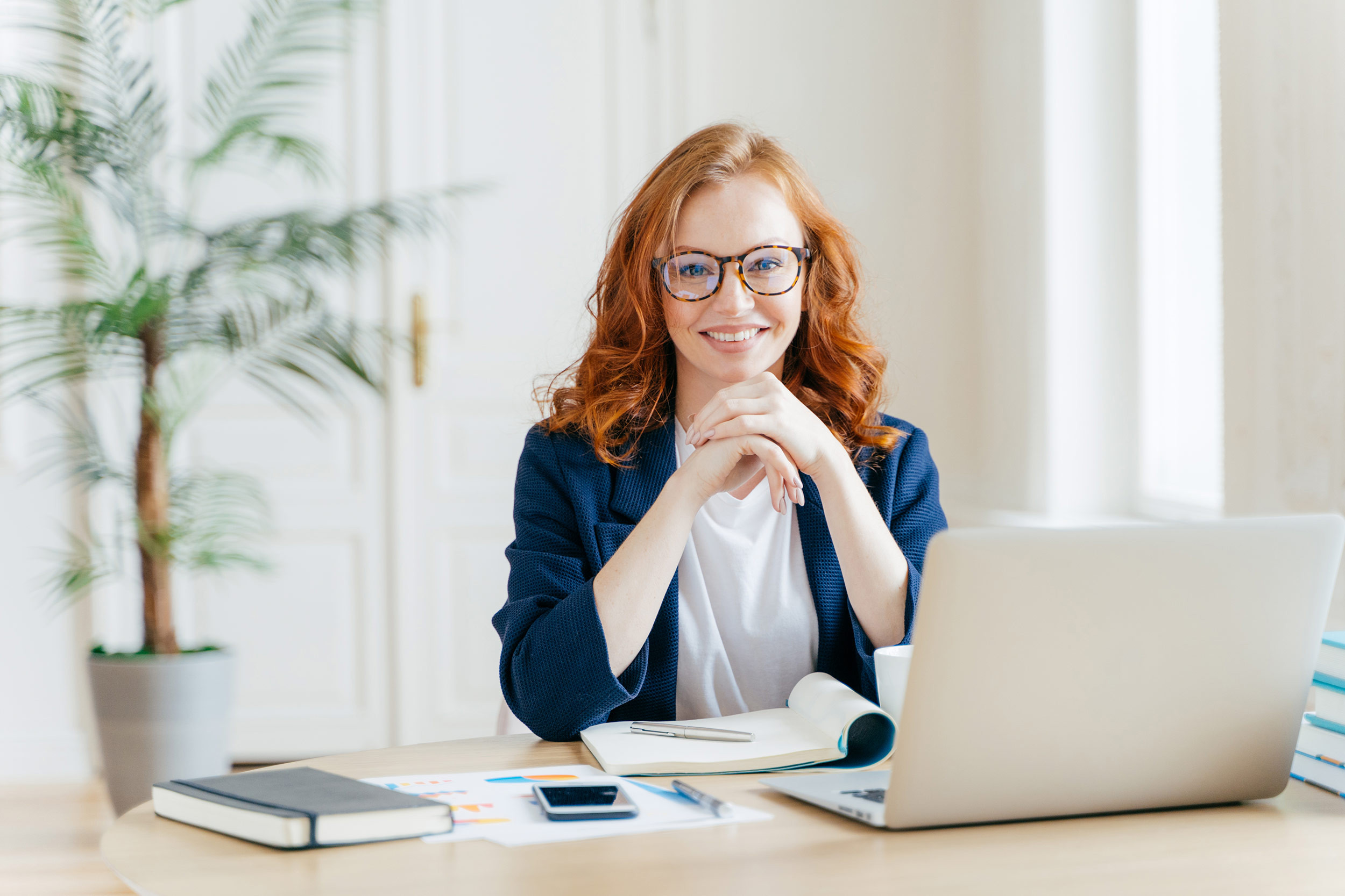 business person with red color hair working on laptop