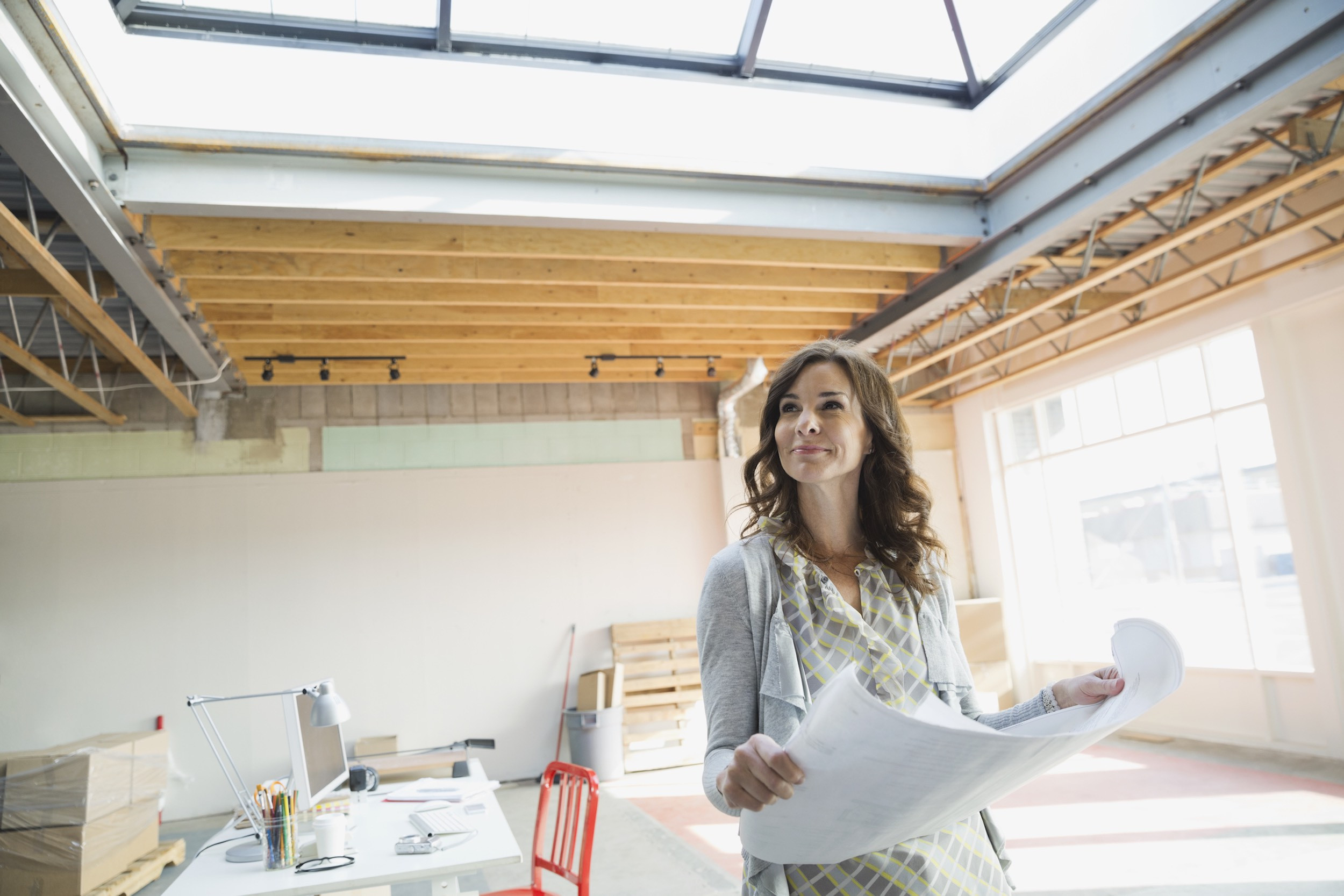 person standing with blueprints in new office