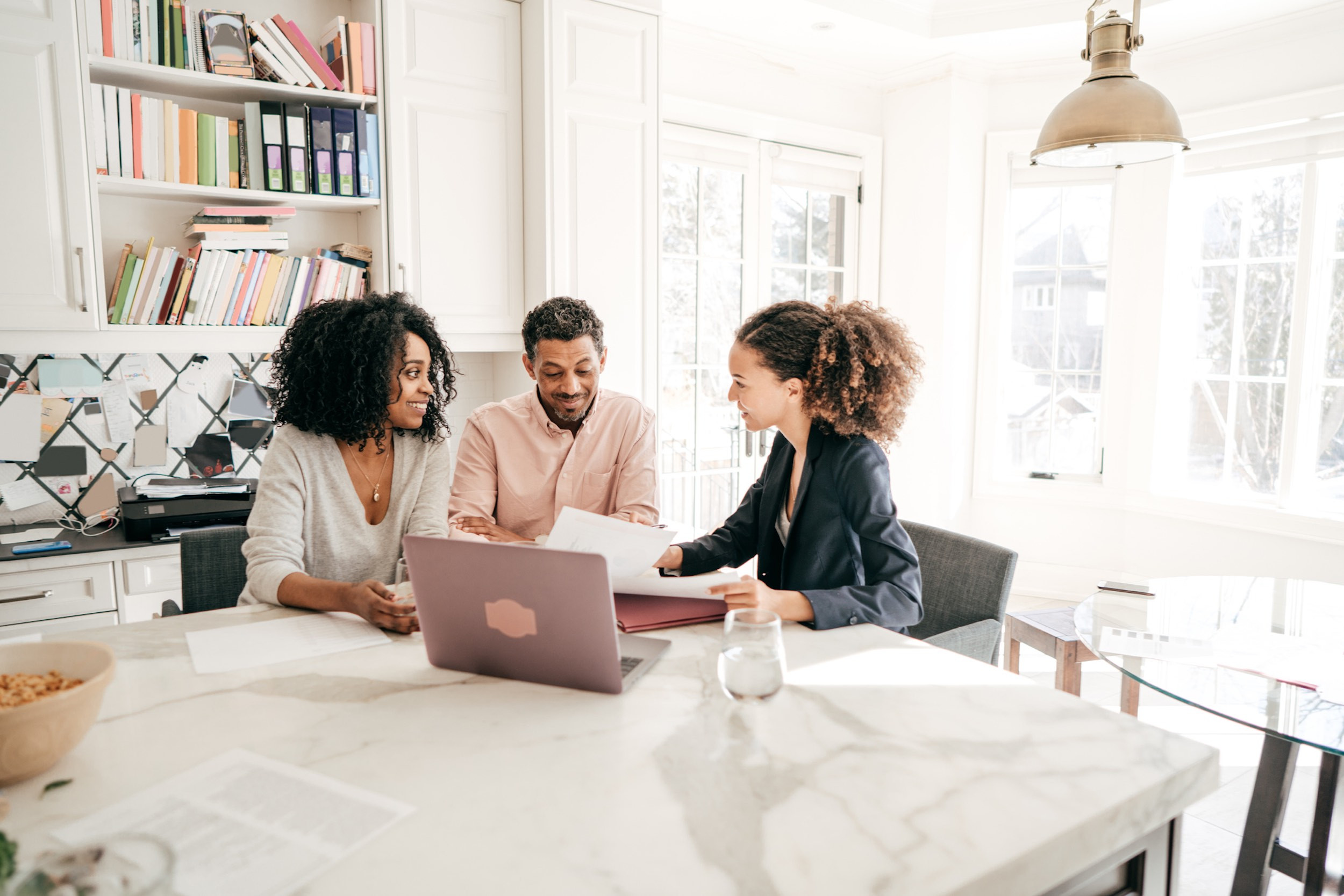 couples working with accountant at kitchen table about paying taxes