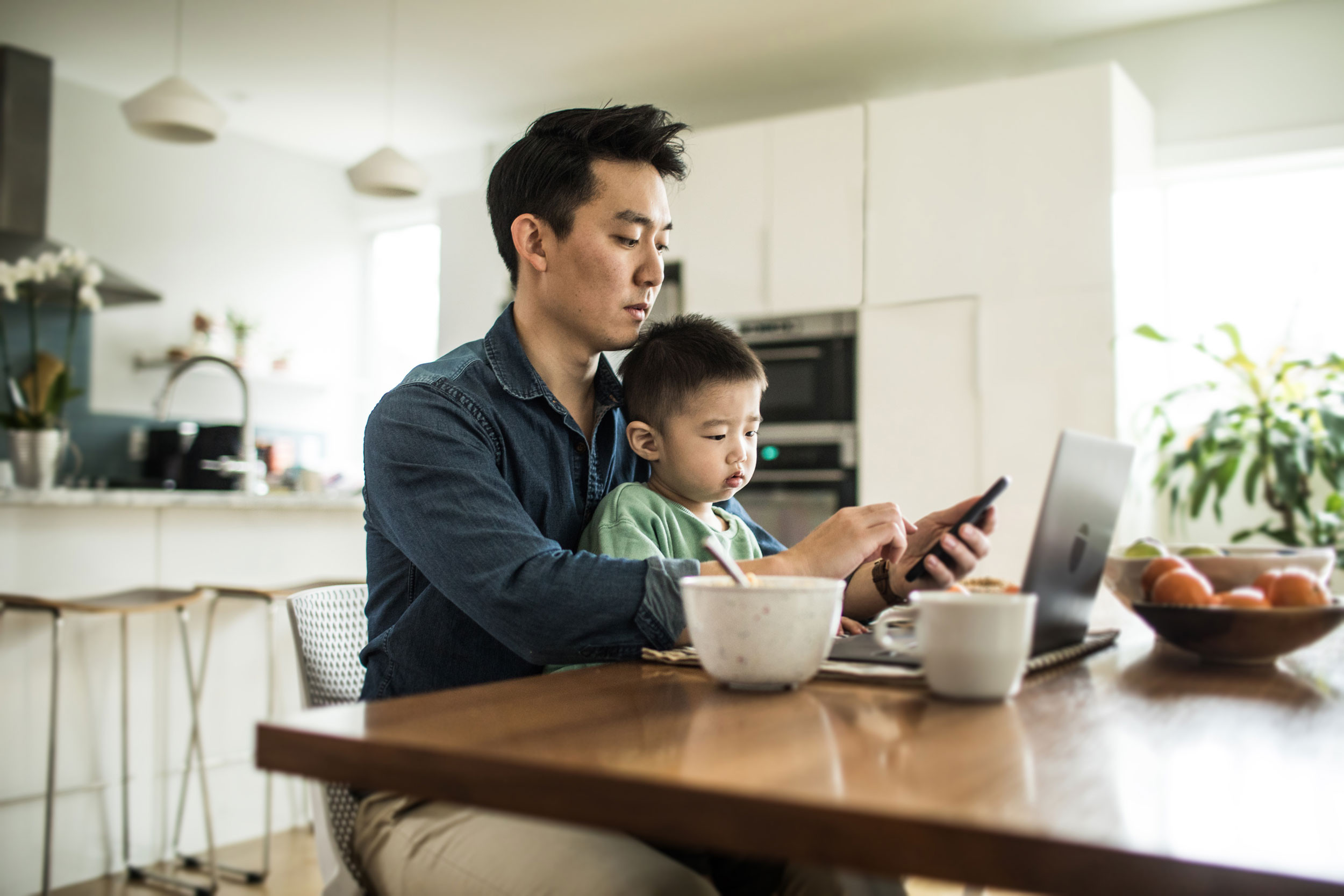 dad and son remotely working on laptop