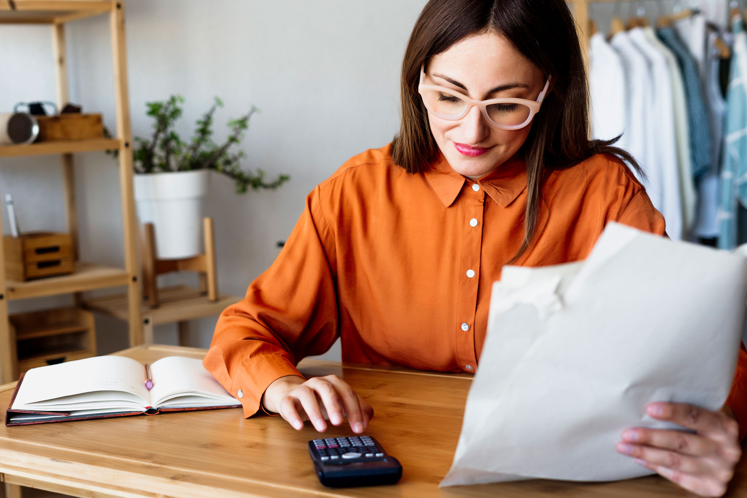 a freelancer person sitting and working at home on desk using calculator