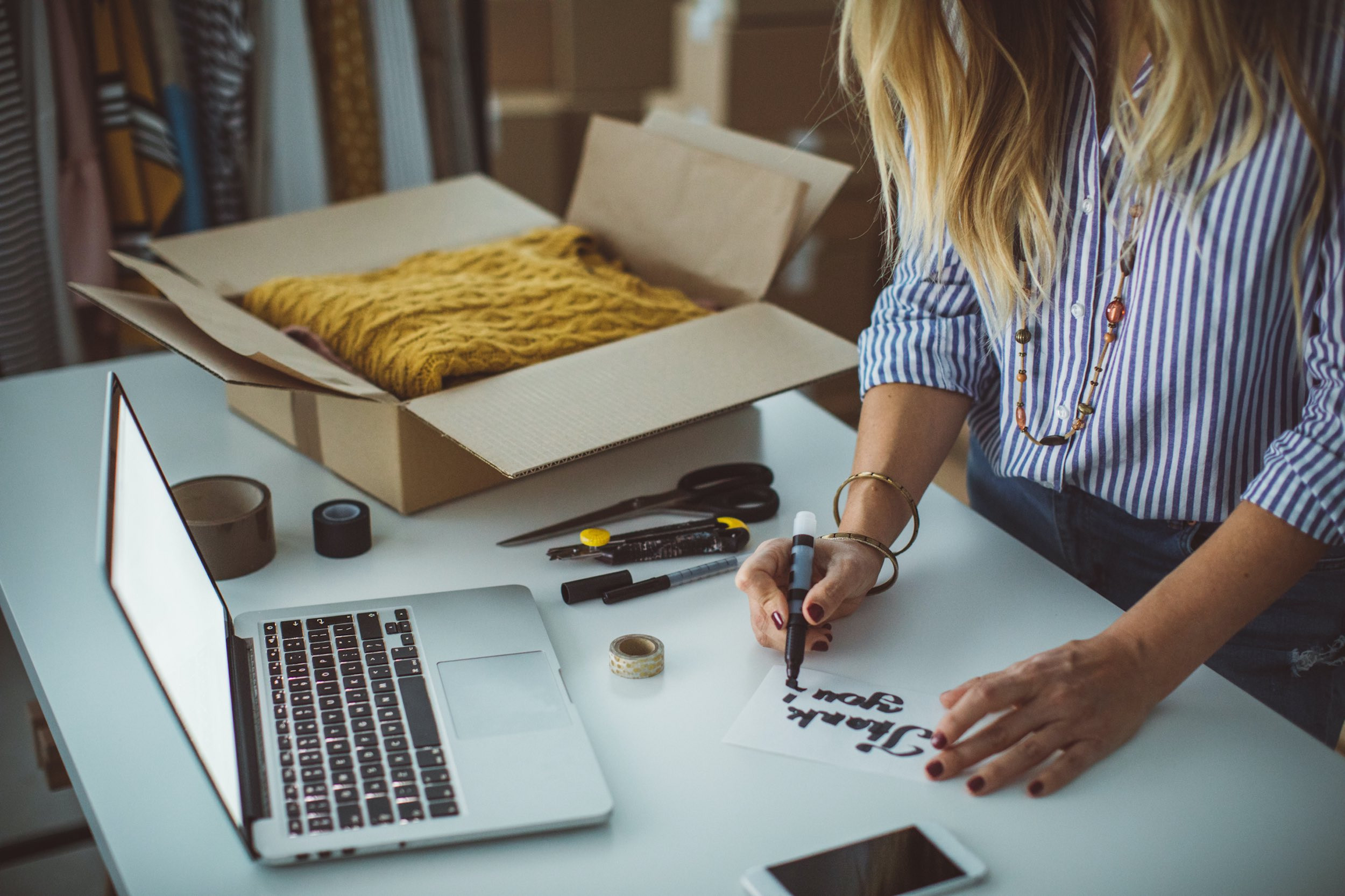 small business owner writing sticky paper with sending packages clothing