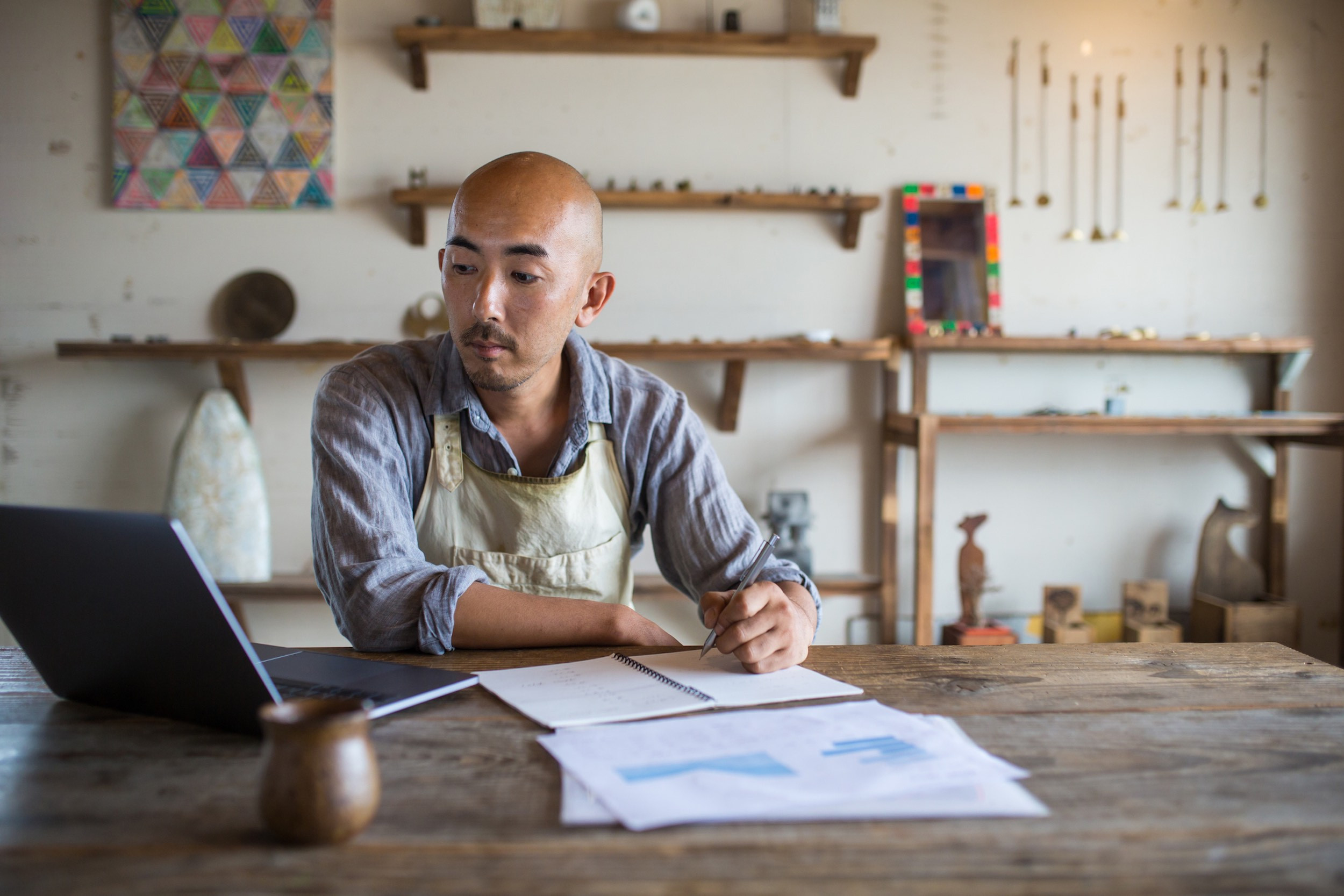 shopkeeper bookkeeping on table with computer