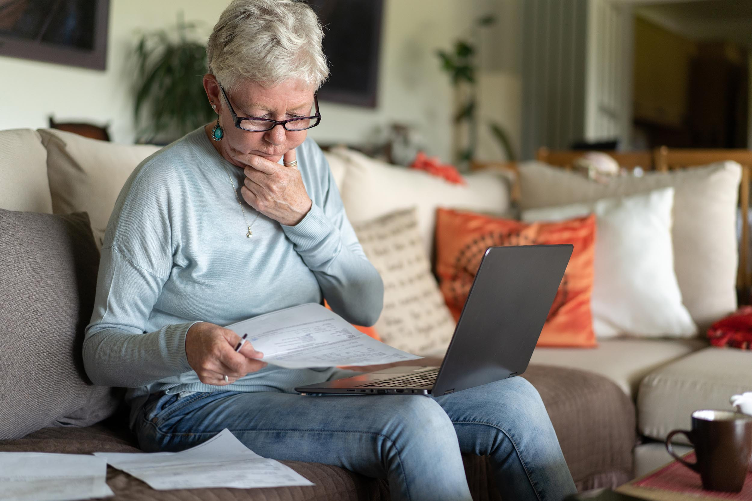 senior lady looking at finance documents with computer