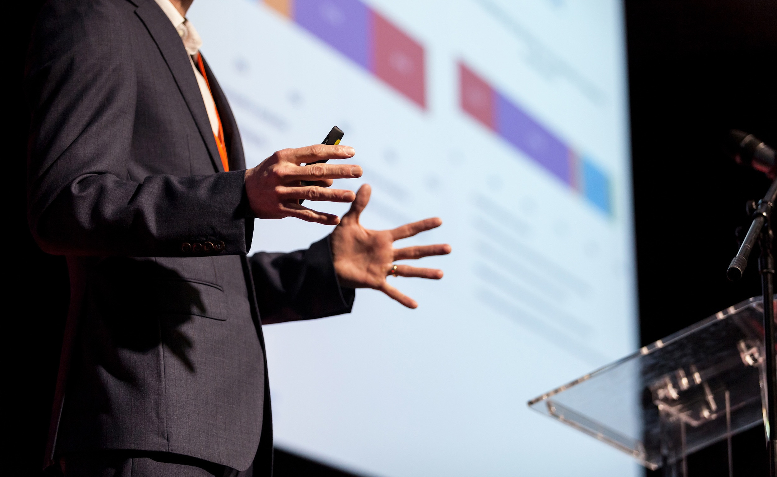 a person presenting slideshow in suit at podium