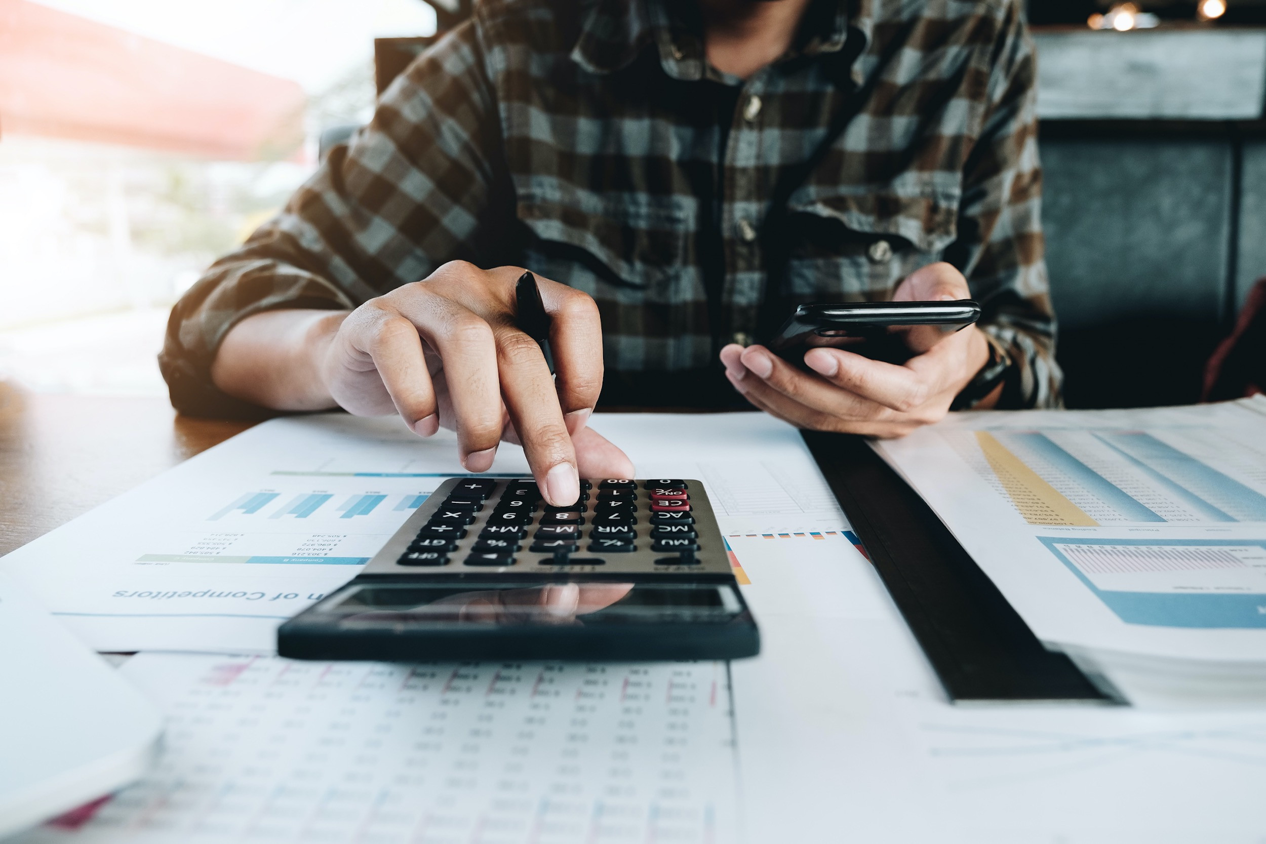 a person working on calculator and documents