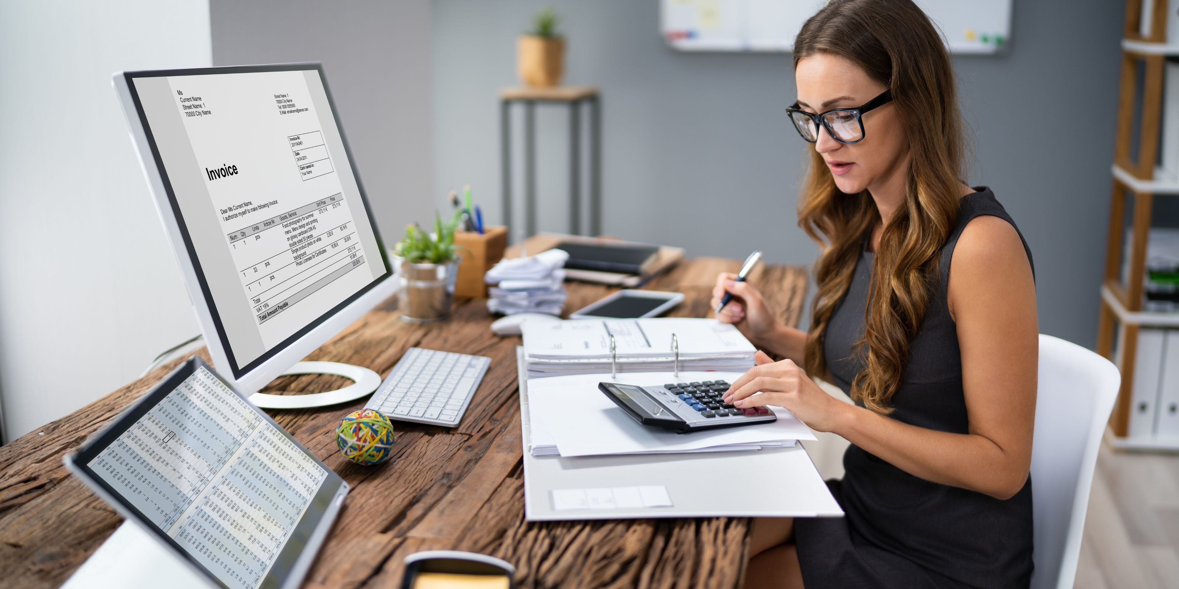 a bookkeeper working on paperwork and computer