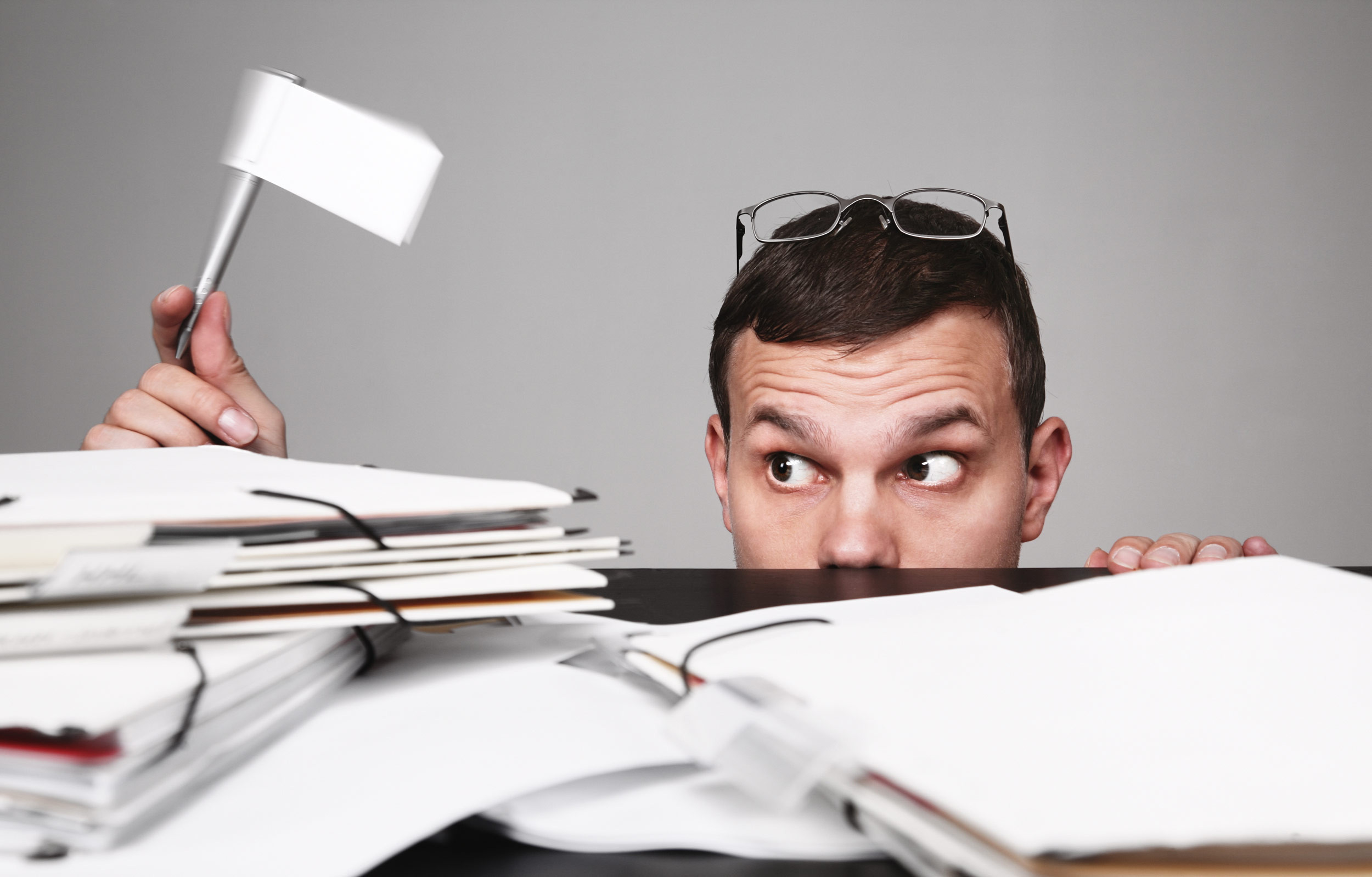 person holding a white flag with stacks of papers