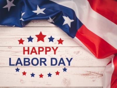 Happy Labor Day text and US flag on wooden background