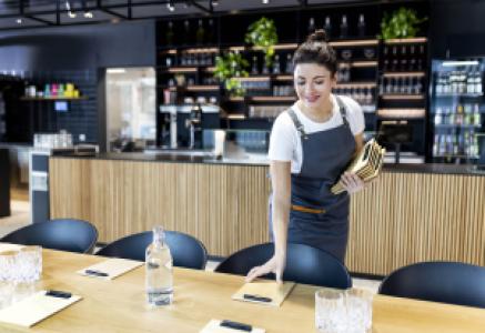 waitress setting up a business meal table in a restaurant