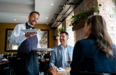a waiter and customers in a high end restaurant