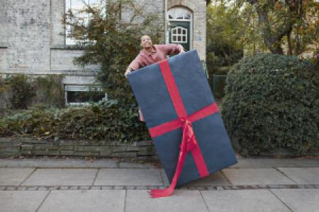 person carrying large wrapped gift box