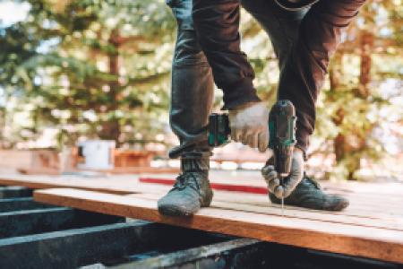 construction worker drilling woodboards