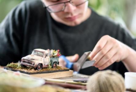 a person painting mini figures as a hobby
