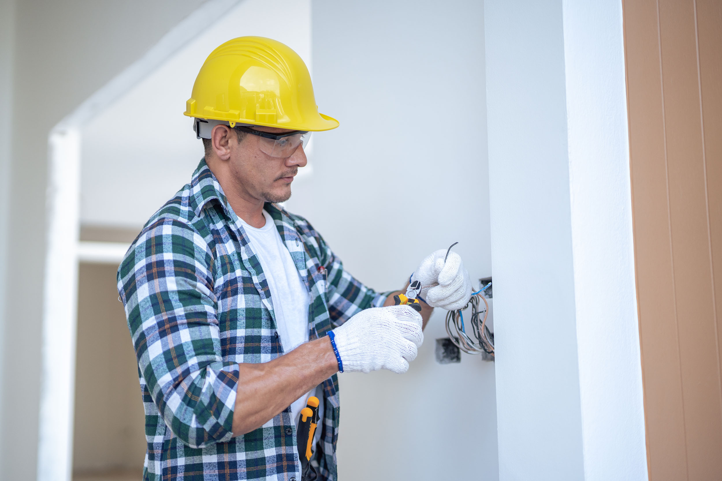 an electrician working on wiring in a wall