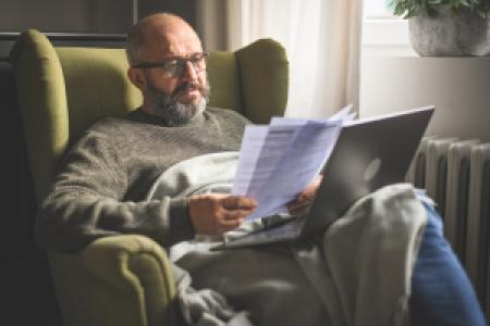a mature adult looking at documents at home