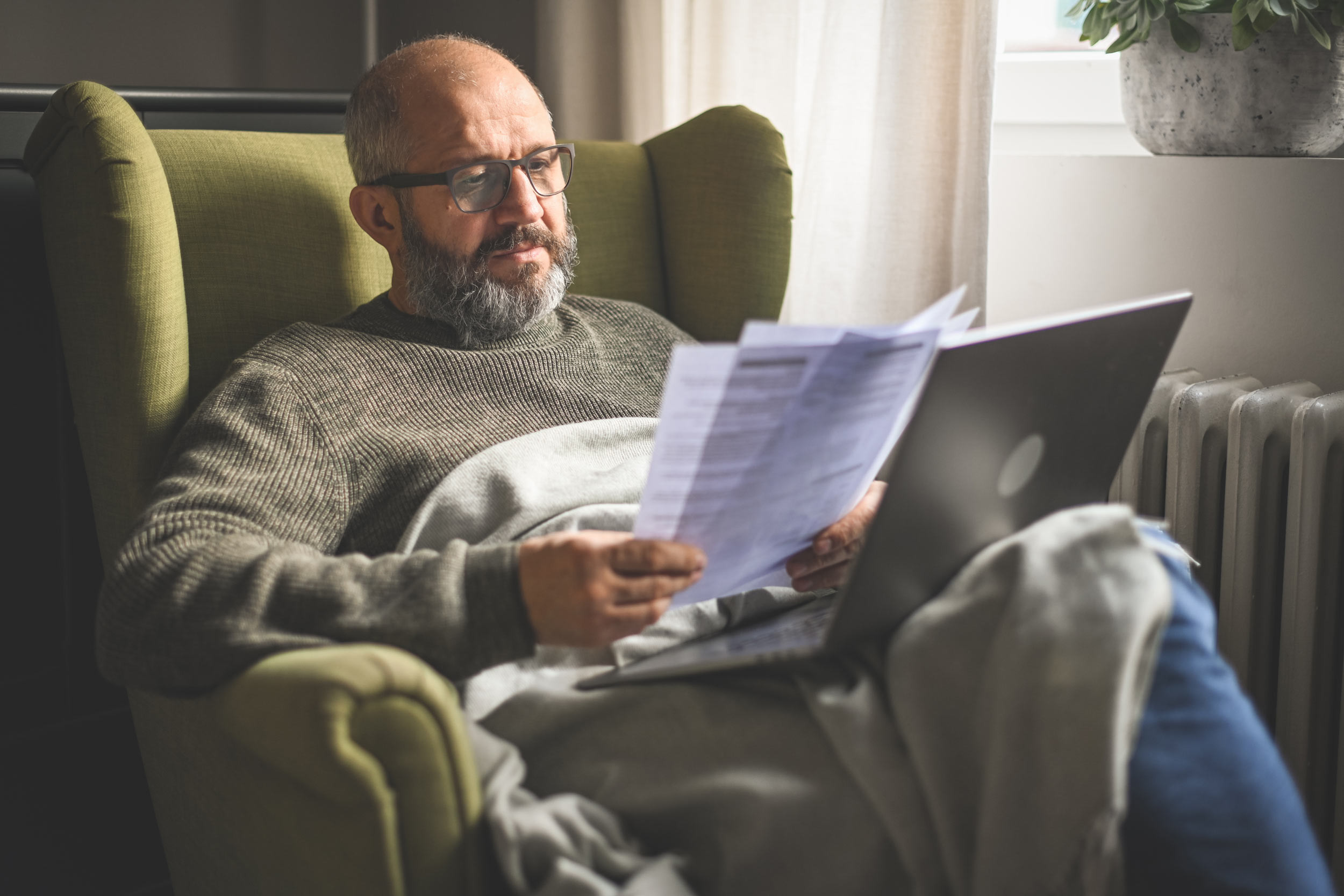 a mature adult looking at documents at home