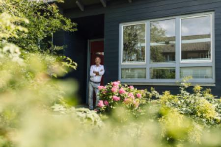 a man leaning on a wall outside his house
